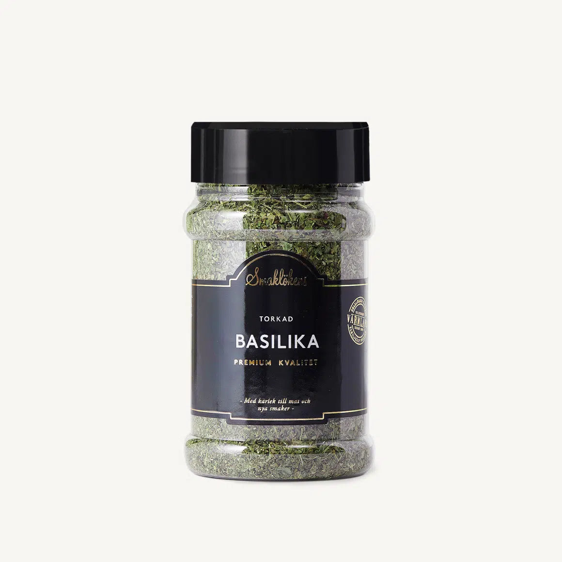 Jar of basil spice with black lid and label on a white background